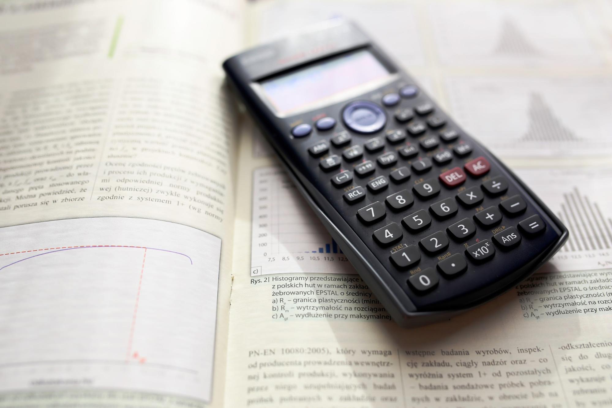 Close up of a calculator sitting on top of a textbook