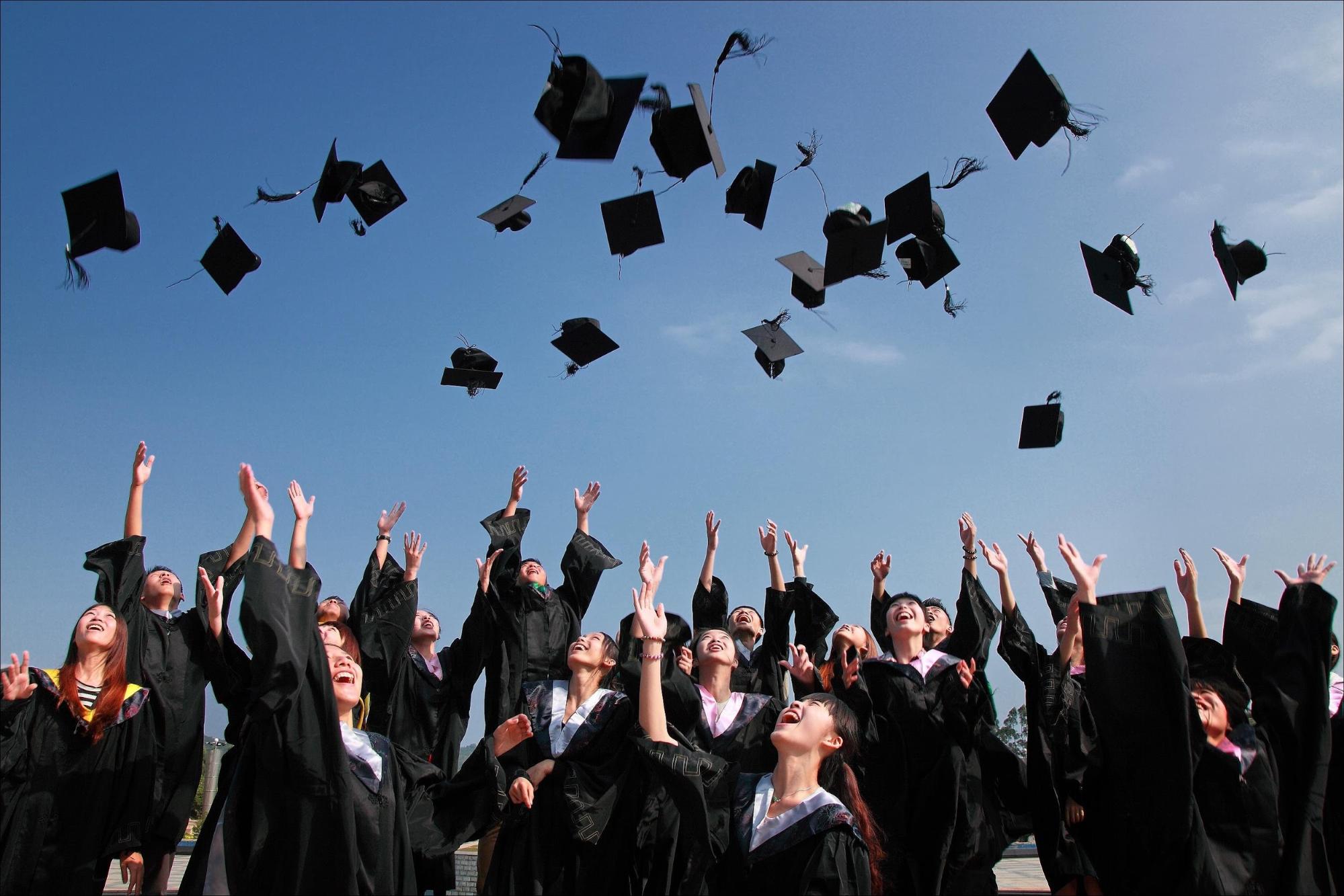 High school graduating class throwing their caps in the air